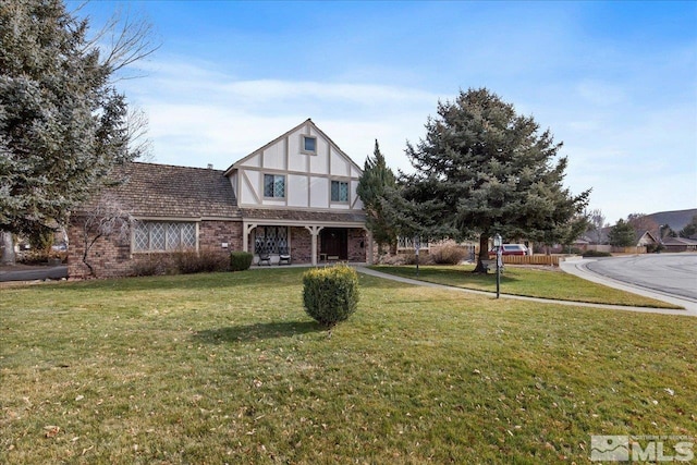 english style home featuring a front lawn