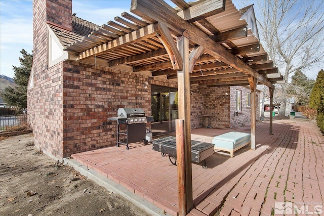 wooden deck featuring a pergola, a patio area, and a grill