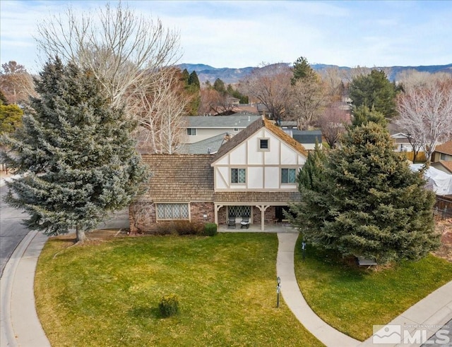 tudor home with a mountain view and a front yard