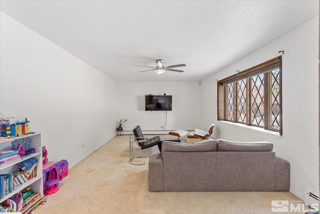 carpeted living room with ceiling fan and a textured ceiling