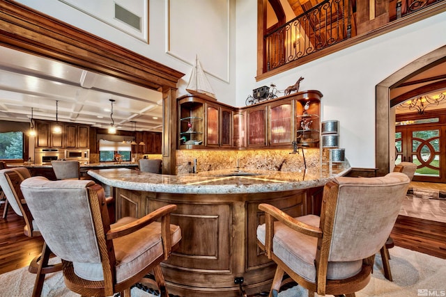 bar with coffered ceiling, dark hardwood / wood-style flooring, french doors, pendant lighting, and oven