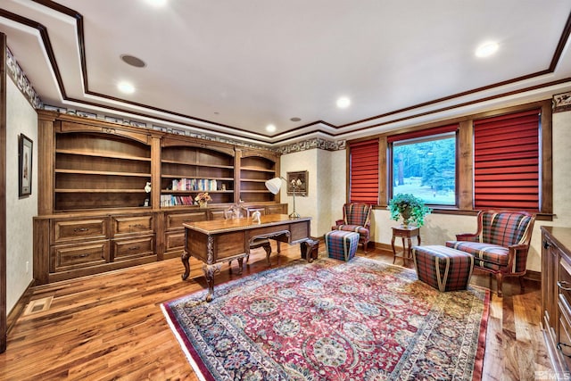 office area featuring a raised ceiling, hardwood / wood-style floors, and ornamental molding