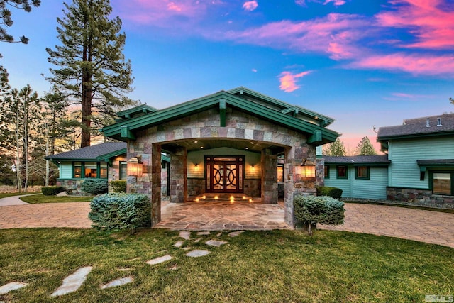 back house at dusk with french doors and a lawn