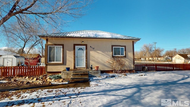 view of front of home with a storage shed