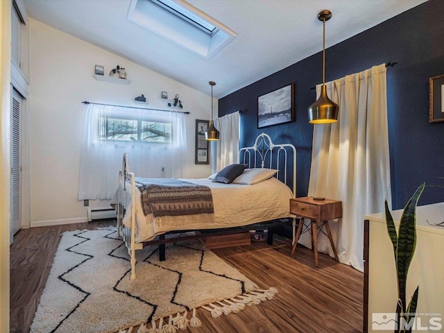 bedroom with lofted ceiling with skylight, a baseboard radiator, and dark hardwood / wood-style flooring