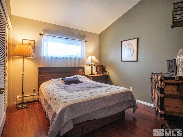 bedroom featuring dark hardwood / wood-style flooring, baseboard heating, and vaulted ceiling