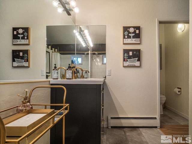 bathroom featuring tile flooring, large vanity, toilet, and a baseboard heating unit