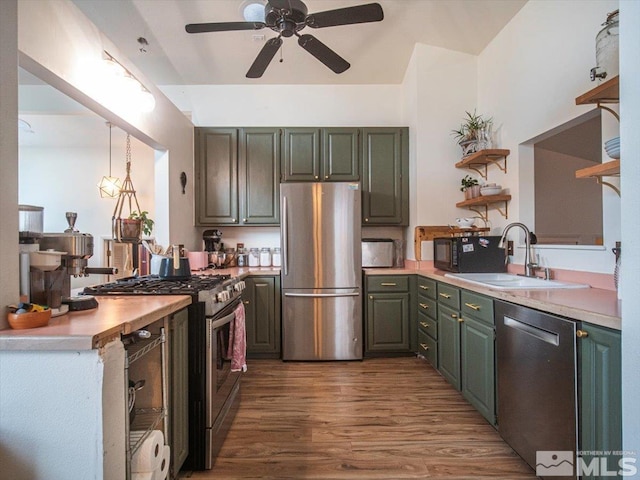 kitchen featuring dark hardwood / wood-style floors, ceiling fan, sink, appliances with stainless steel finishes, and decorative light fixtures