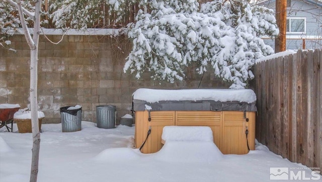 snow covered patio with a covered hot tub