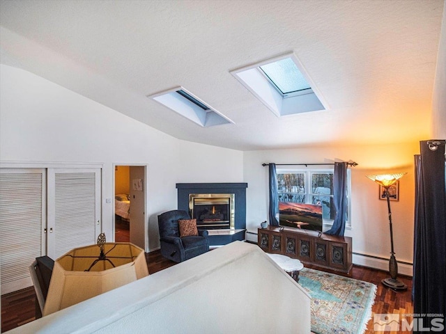 living room featuring lofted ceiling with skylight, dark hardwood / wood-style floors, and a baseboard radiator