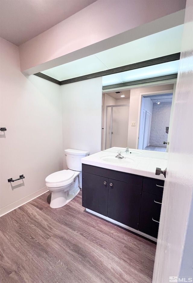 bathroom featuring toilet, vanity, and wood-type flooring