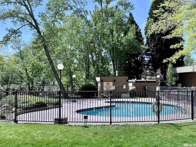 view of swimming pool with a yard