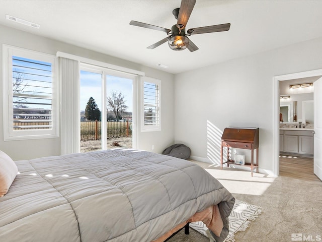 carpeted bedroom featuring connected bathroom, access to outside, ceiling fan, and sink