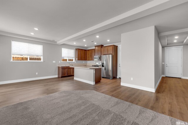 kitchen with a center island, appliances with stainless steel finishes, and hardwood / wood-style flooring