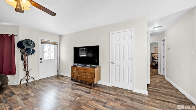 living room with ceiling fan and dark wood-type flooring