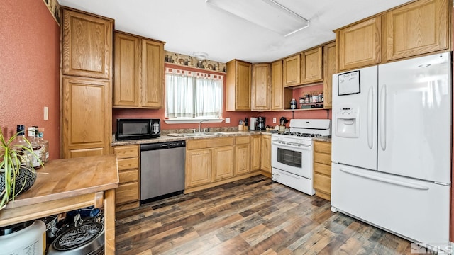 kitchen with sink, white appliances, light stone counters, and dark hardwood / wood-style floors