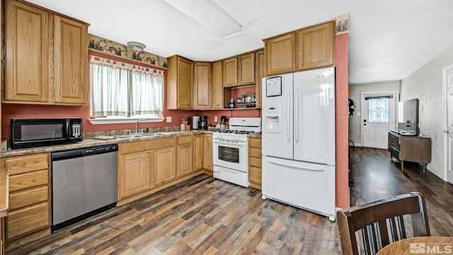 kitchen with white appliances, sink, dark hardwood / wood-style flooring, and light stone counters