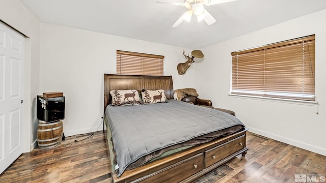 bedroom with a closet, ceiling fan, and dark hardwood / wood-style flooring