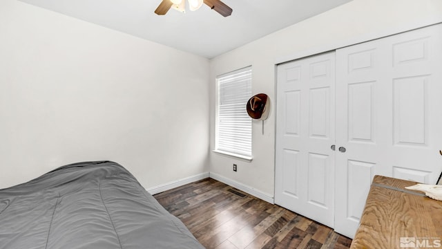 bedroom with a closet, dark hardwood / wood-style floors, and ceiling fan