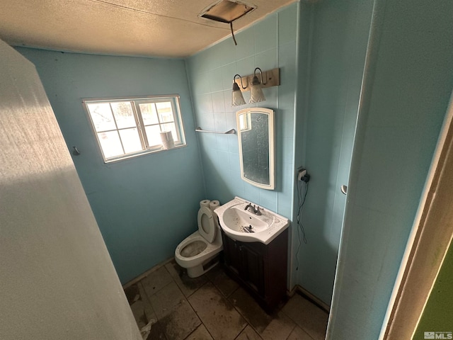 bathroom with toilet, tile floors, a textured ceiling, and vanity