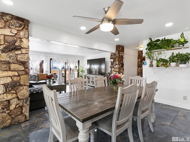 dining space featuring ceiling fan and dark tile floors