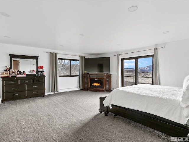 bedroom featuring light colored carpet and multiple windows