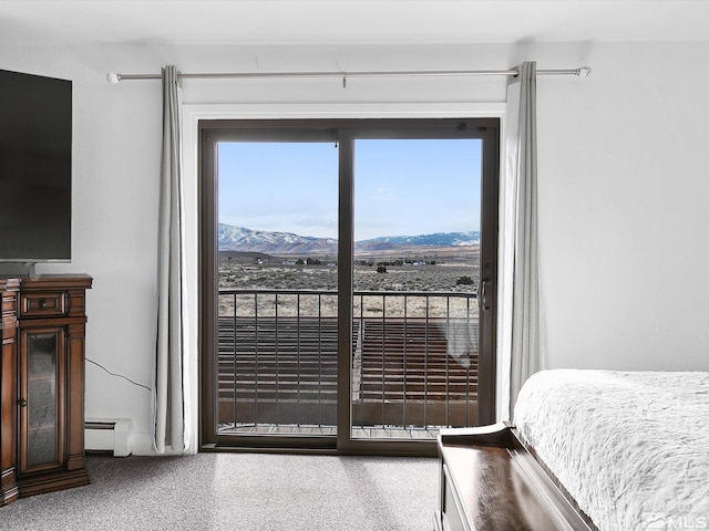 carpeted bedroom featuring a mountain view and baseboard heating