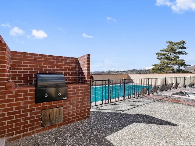 view of terrace with a covered pool and an outdoor kitchen