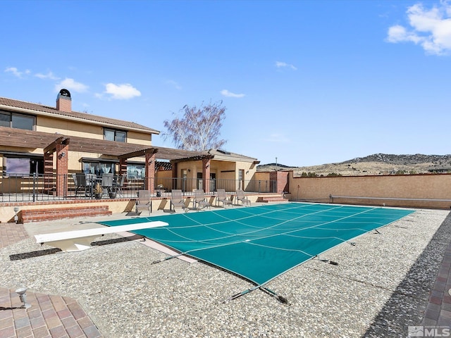 view of pool featuring a diving board and a patio