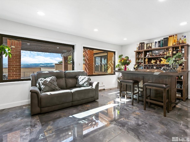 tiled living room featuring a baseboard heating unit and indoor bar