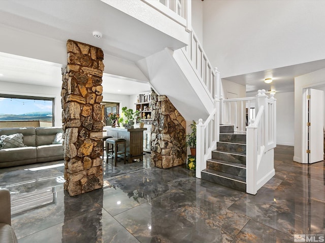 interior space featuring dark tile floors and decorative columns