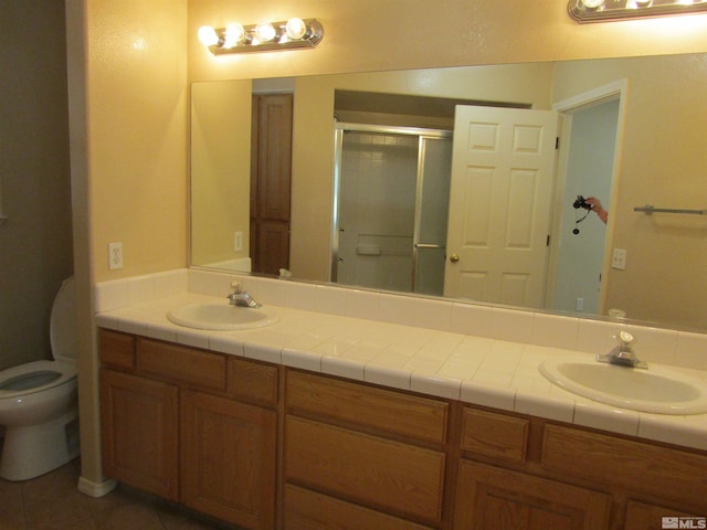 bathroom with toilet, dual bowl vanity, and tile flooring