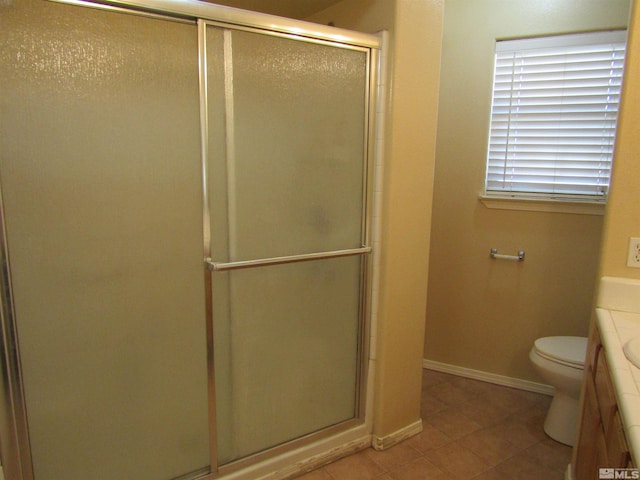 bathroom with toilet, a shower with door, tile floors, and vanity