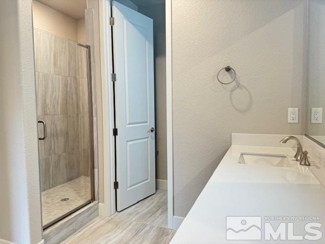 bathroom with a shower with door and vanity