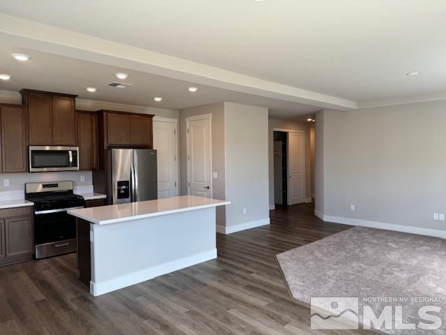 kitchen featuring dark brown cabinets, appliances with stainless steel finishes, dark hardwood / wood-style floors, and a kitchen island