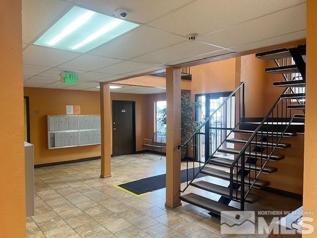 stairway with a paneled ceiling