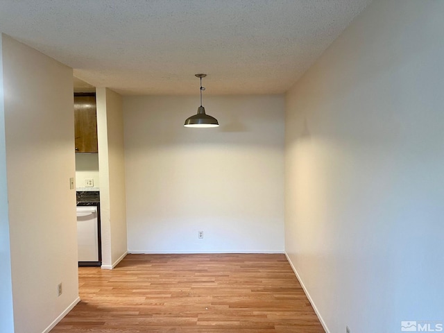 unfurnished dining area featuring light hardwood / wood-style floors and a textured ceiling