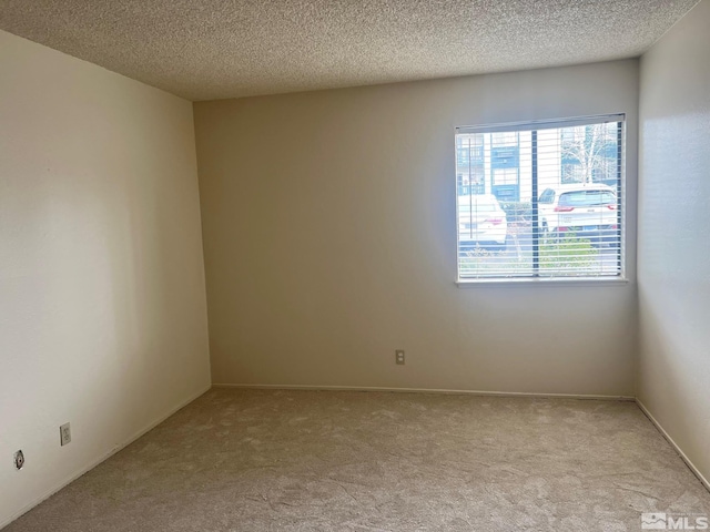 carpeted empty room featuring a textured ceiling