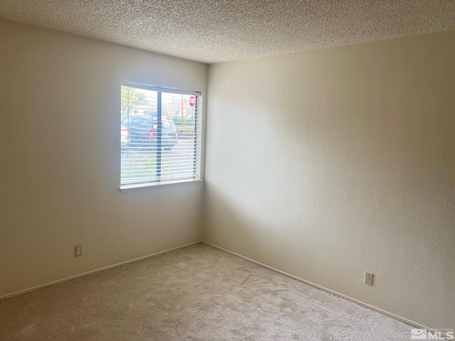 carpeted spare room featuring a textured ceiling