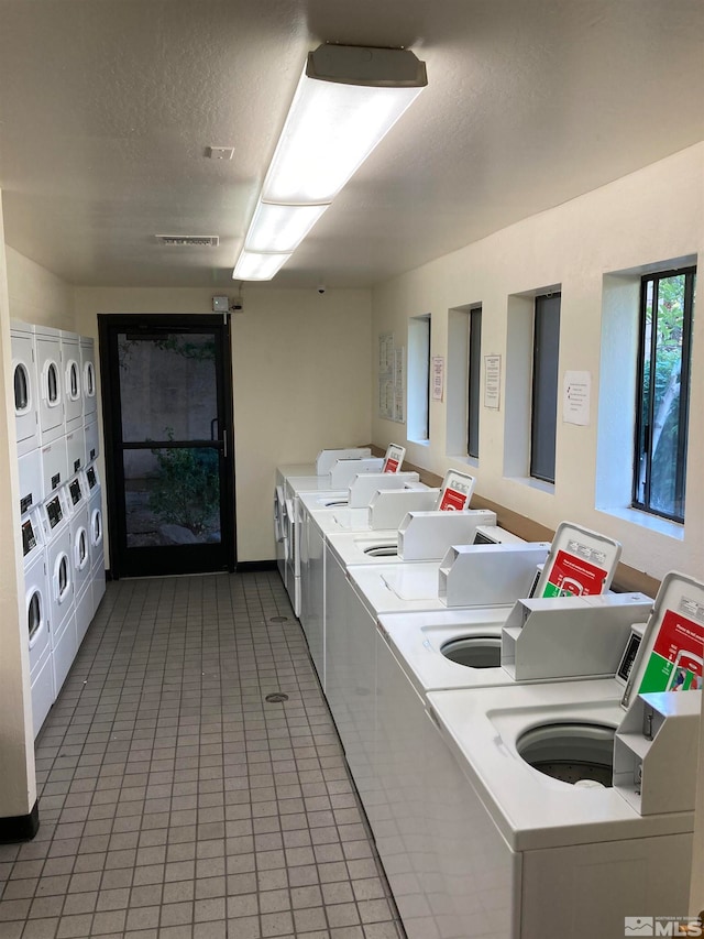 kitchen featuring tile patterned floors, washer and clothes dryer, a textured ceiling, and stacked washing maching and dryer