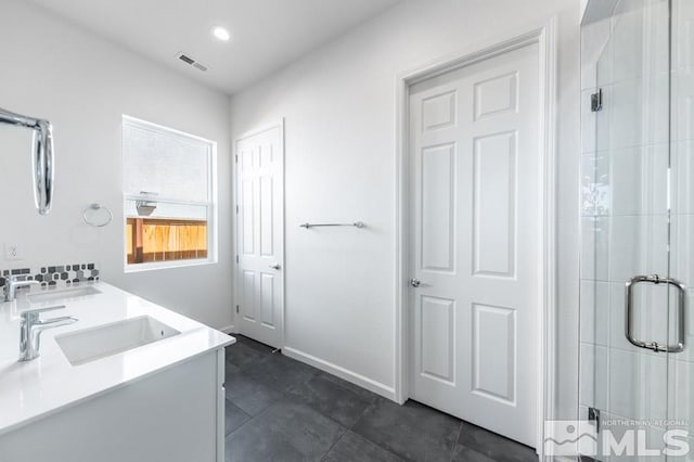 bathroom featuring tile patterned flooring, a shower with door, and vanity