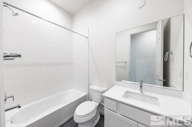 full bathroom with tile patterned floors, toilet, tiled shower / bath, and vanity