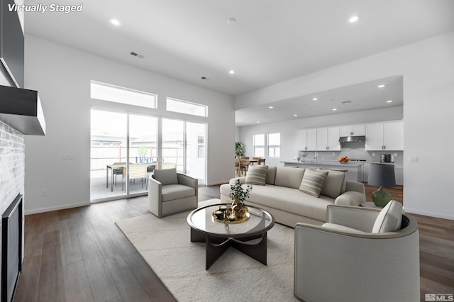 living room featuring a brick fireplace and light wood-type flooring