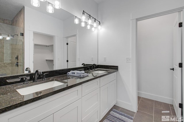 bathroom featuring walk in shower, double vanity, and tile floors