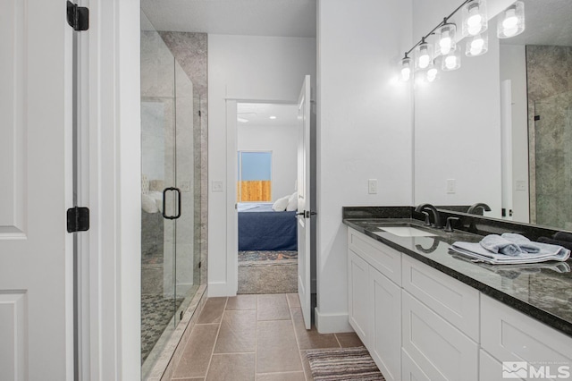 bathroom featuring a shower with door, tile flooring, and vanity