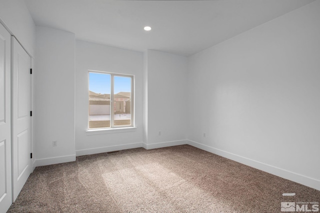 empty room featuring dark colored carpet