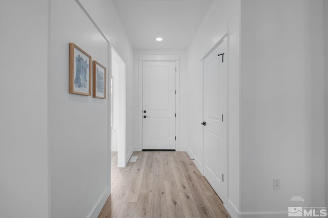 corridor with light hardwood / wood-style flooring