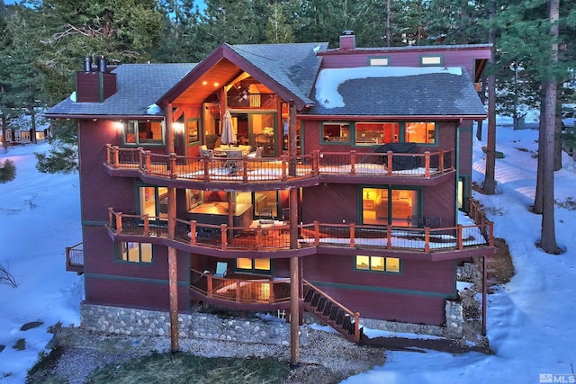 snow covered back of property with a balcony