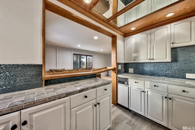 kitchen featuring tasteful backsplash, white cabinetry, and light hardwood / wood-style flooring