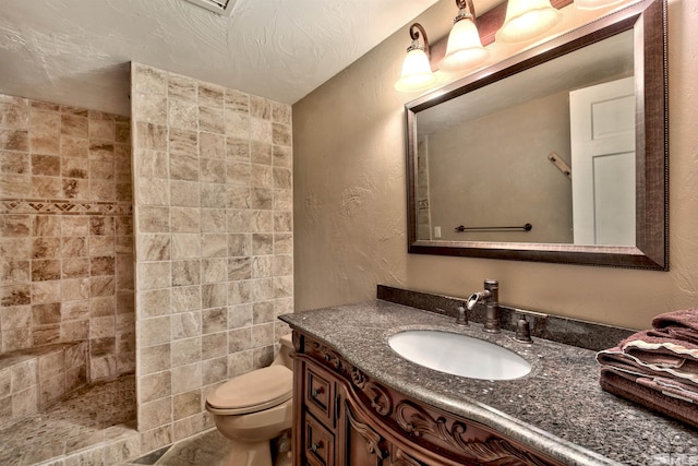 bathroom featuring large vanity, toilet, and tile walls